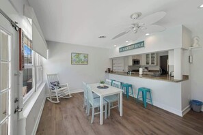 Cozinha moderna com ilha central, armários brancos e ventilador de teto.