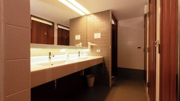 A modern bathroom with a long vanity, multiple sinks, and a mirror.
