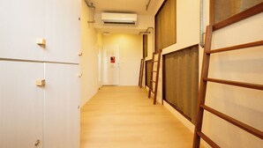 A hallway with wooden flooring, white walls, and a door at the end. - Cattail pocket Inn (Taipei)