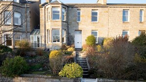 A stone building with a central entrance and a staircase leading to the door.