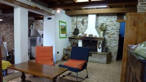 Un salon chaleureux avec une cheminée, une table à manger et deux chaises.