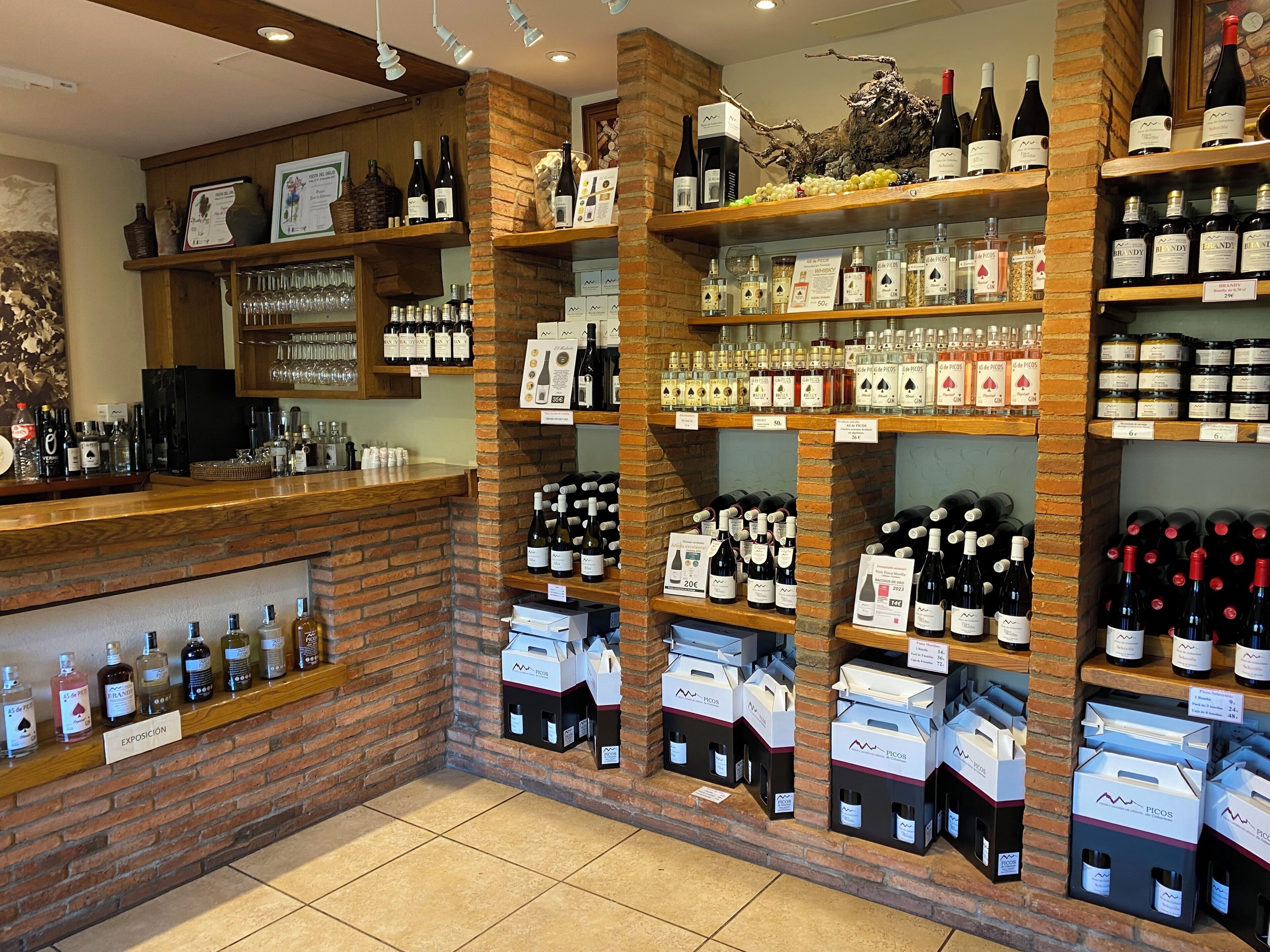 Una tienda de vinos con estantes llenos de botellas, copas y cajas.