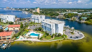 A waterfront hotel with multiple buildings, a central pool, and marina access. - Dolphin Point 305b 2 Bedroom Condo by RedAwning (Destin)