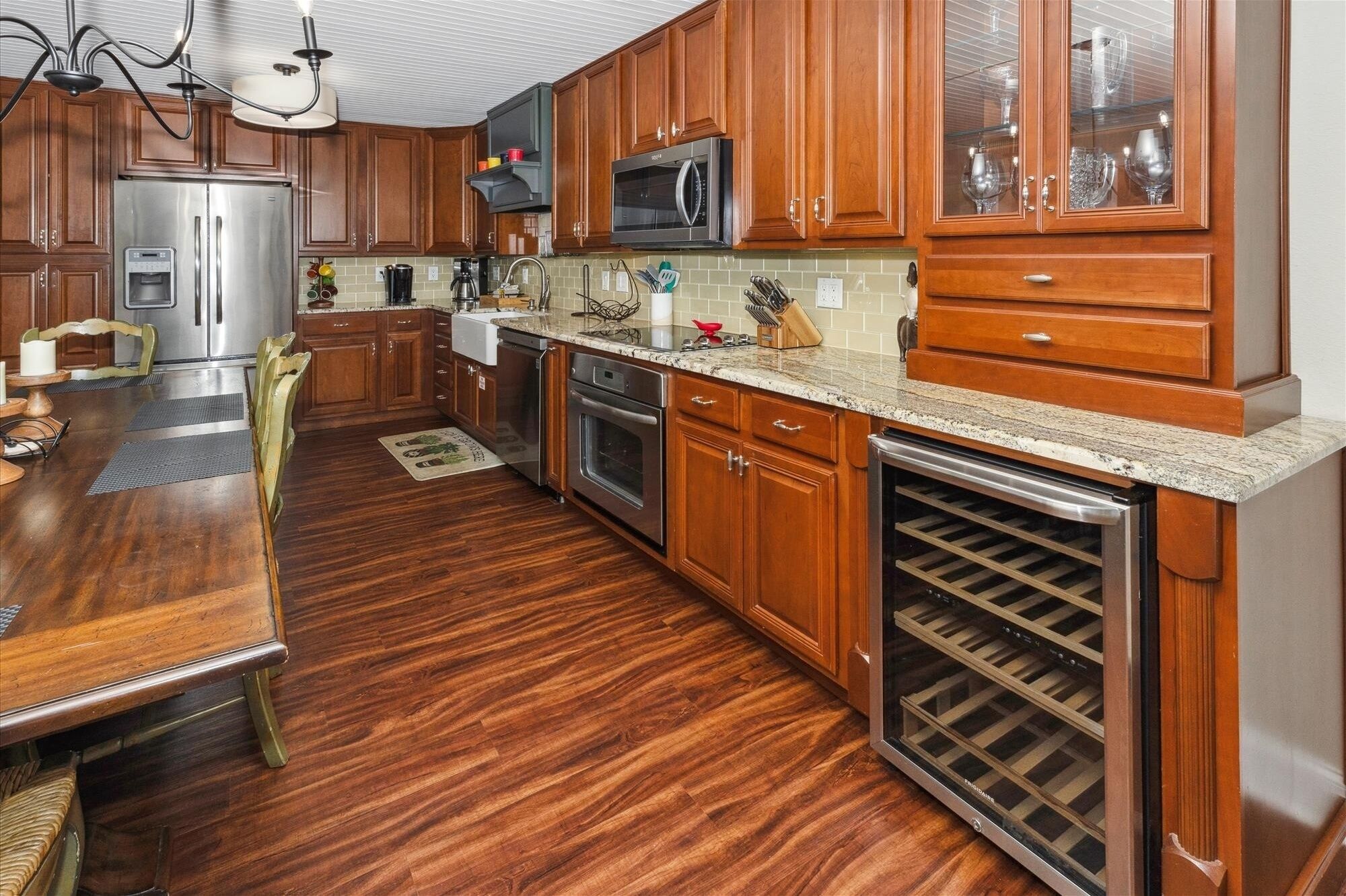 A kitchen with wooden cabinets, stainless steel appliances, and a built-in wine cooler.