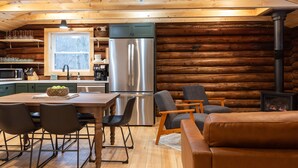 L’intérieur d’une cabane en rondins comprend une cuisine, un coin repas et un espace détente.