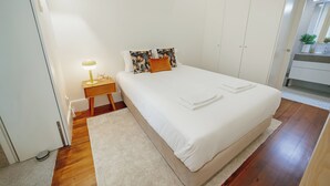 A neatly arranged bedroom with a bed, bedside table, lamp, and a small plant. - Home with a Pool by Vacationy (Porto)