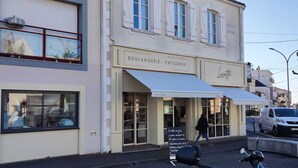 Een gebouw met een bord waarop 'BOULANGERIE - PATTISERIE' en 'Lucette' staat.