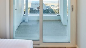 Una stanza con un'ampia porta-finestra scorrevole che dà su un balcone con vista sull'oceano.