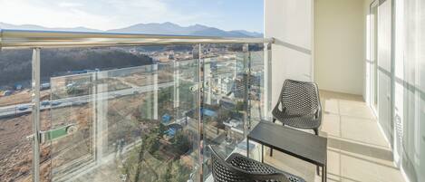 Un balcón con vistas despejadas a un paisaje urbano y montañas al fondo.