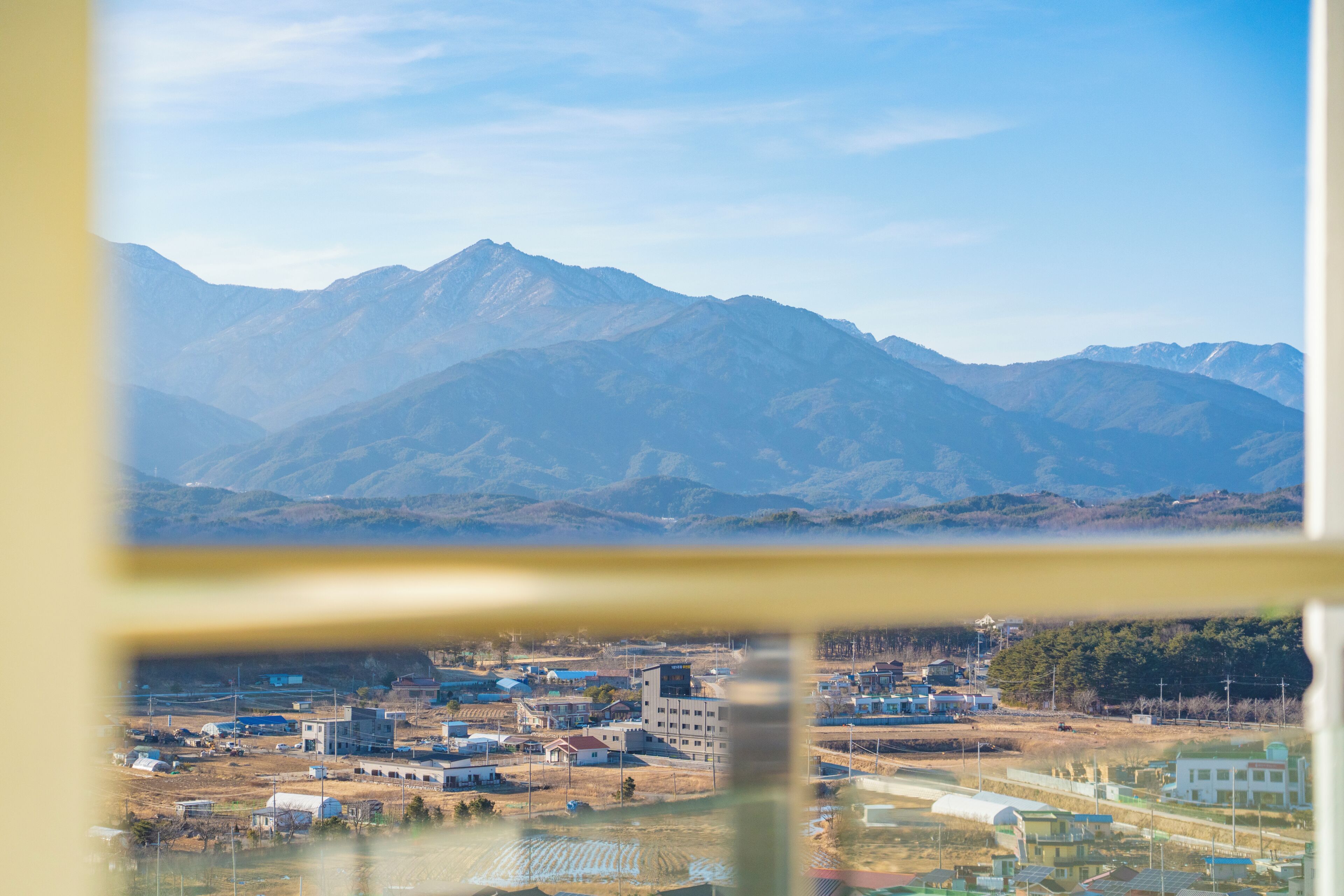 A mountainous landscape with a town in the foreground.
