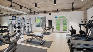A spacious gym with various exercise equipment, including treadmills, weight machines, and free weights.
