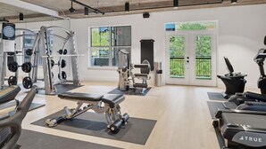 A modern gym with various exercise equipment, large windows, and a clean, spacious layout. - Austin Gorgeous 1BD 1BA Downtown Apartment (Austin)