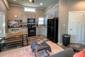 Une cuisine moderne avec un coin repas, un grand téléviseur et un espace salon confortable.