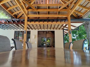 A wooden pergola structure with a thatched roof, a dining table with chairs, and a view of the outdoors. - Ocean view Casa Gauguin.
Forget your worries in this spacious and serene space. (Playa dominicalito)