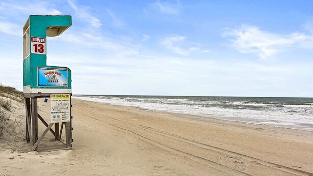 A lifeguard tower labeled 'TOWER 13' with a sign for 'Mariners Grill' and safety warnings. - Do you want to go to the beach "Oar Knot"? (Carolina Beach)