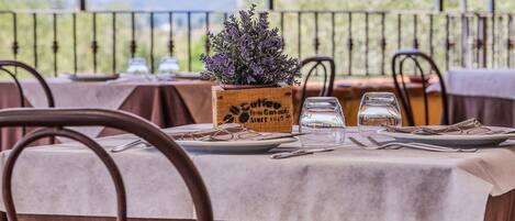 A table set for dining with a view of mountains, a wooden planter with lavender, and a sign reading "Coffee from Guatemala."
