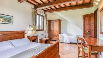 Ein Schlafzimmer mit einem hölzernen Bett, einem Nachttisch, einem Schreibtisch und einem Stuhl.