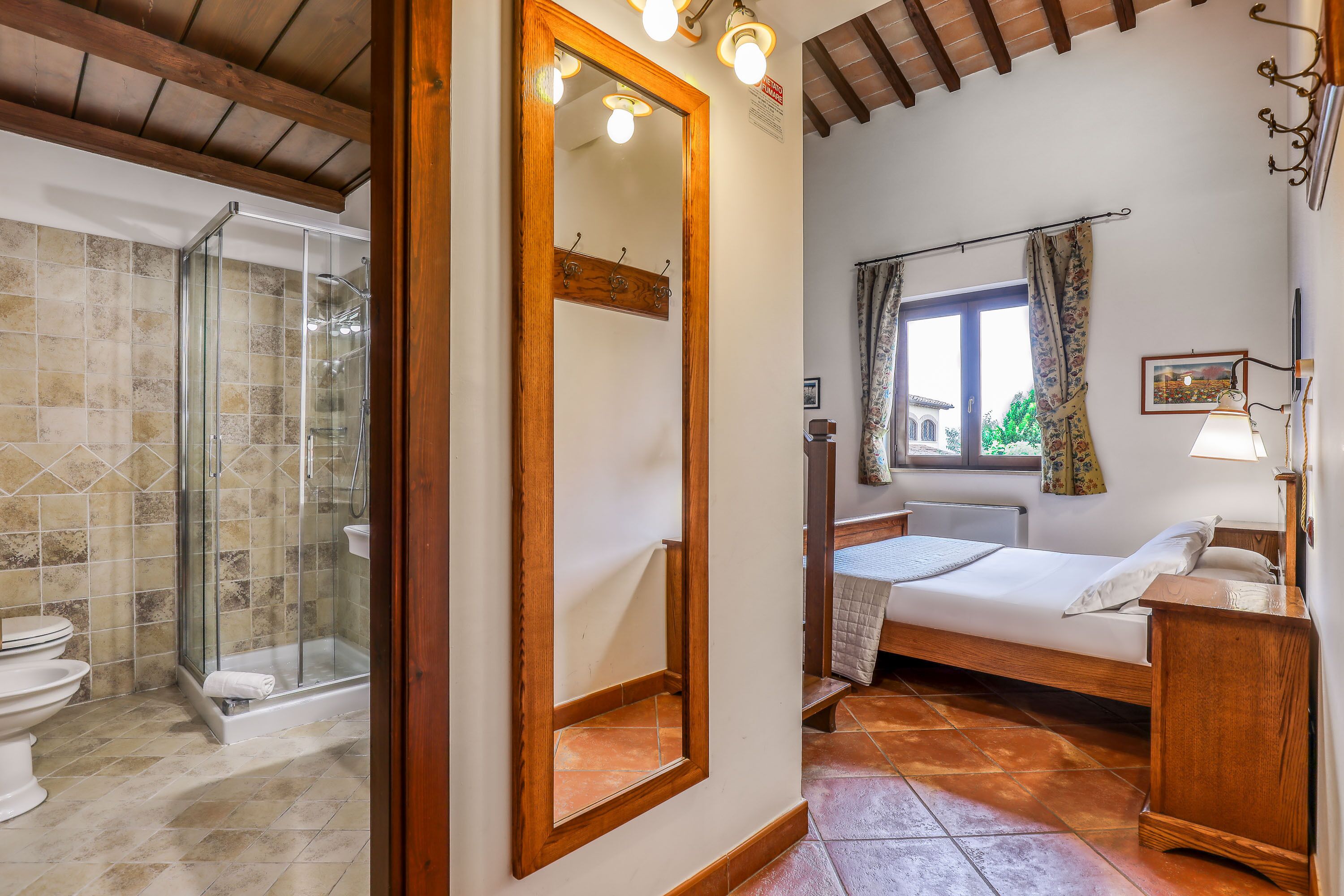 Un baño con cabina de ducha de vidrio, inodoro y lavamanos.