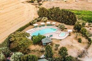 Una piscina al aire libre de temporada, sombrillas