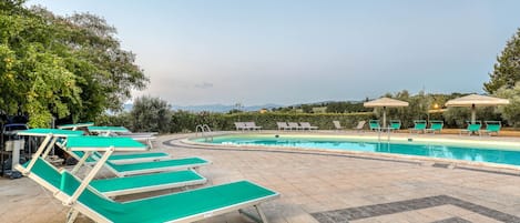 Una piscina al aire libre de temporada, sombrillas