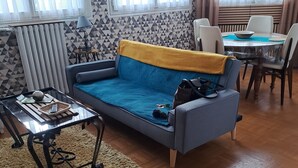 Una sala de estar con sofá, mesa de centro y mesa de comedor.