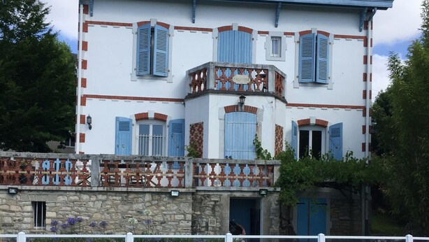Un bâtiment à deux étages avec une piscine devant.