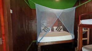 A room with a bunk bed, a mosquito net, and a wooden bunk bed frame. - The Beachaven Chalets Kota Belud (Kota Belud)