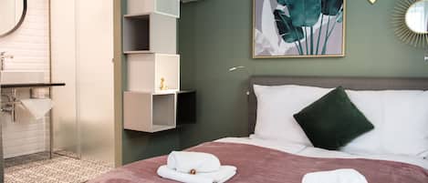 Quarto de hotel com cama, banheiro e chuveiro.