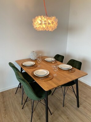 A dining table set with plates, glasses, and a decorative light fixture.