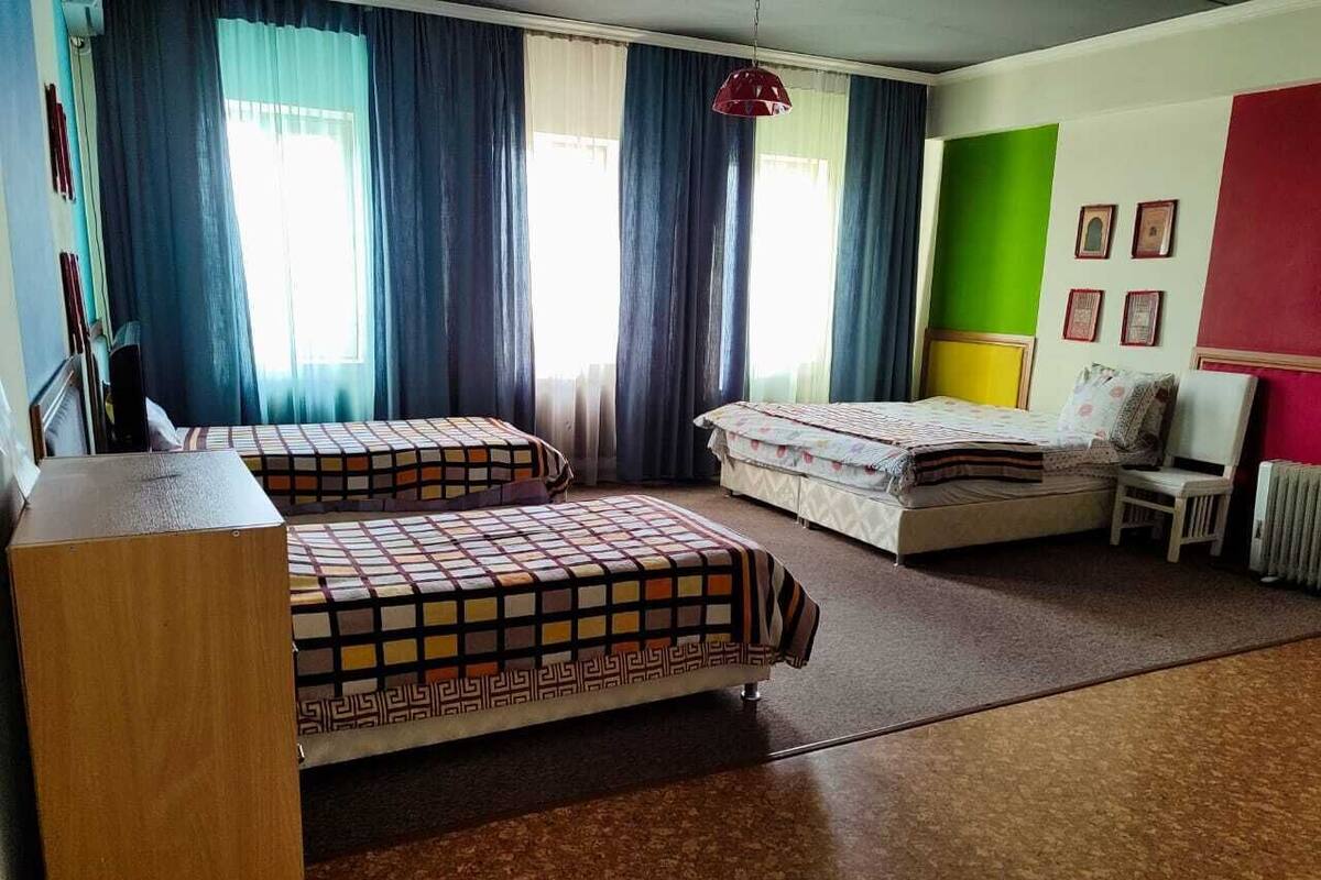 A dormitory room with two beds, a desk, and a chair.