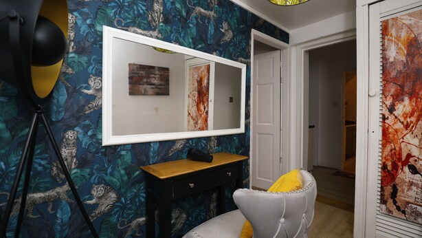 Een kamer met een spiegel, een bureau en een stoel.