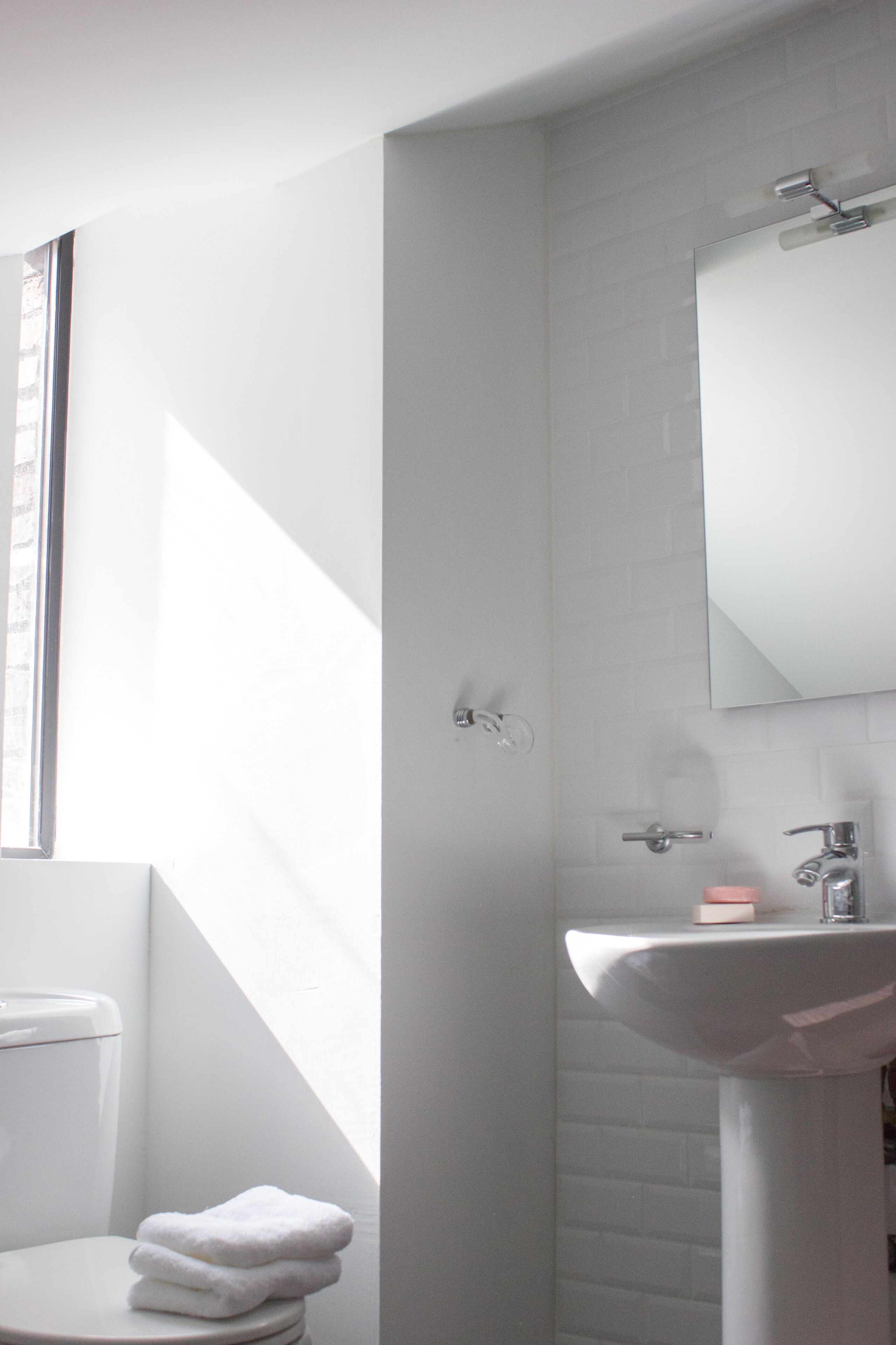 A bathroom with a white sink, a mirror, and a toilet.