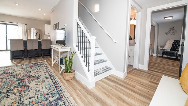 A modern apartment with a staircase, a dining area, and a living space. - Charming 3-bedroom, 2 bathroom house with outdoor space in Winona (Winona)