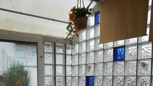 A cozy room with a wooden table and chairs, a window with decorative glass panes, and a view of the outdoors. - Gemütliche Erdgeschosswohnung mit Terrasse in Ortsrandlage in Waibstadt (Waibstadt)