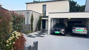 A modern two-story building with a garage parking two cars. - Maison Moderne Avec Piscine Chauffée, à 1km de L'avenue de Gaulle à La Baule (Guérande)