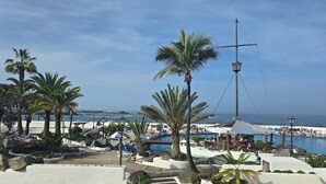 Ett semesterparadis med pool, palmer och utsikt över havet.