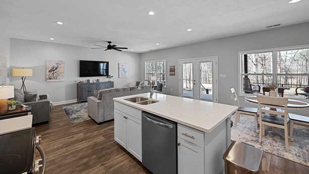 A modern kitchen with a central island, built-in appliances, and a dining area with outdoor seating. - Newly built Chalet on State Park Golf Course 5 min from Pickwick Lake! (Counce)