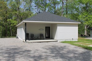Guest house with a front porch and tranquil surroundings.