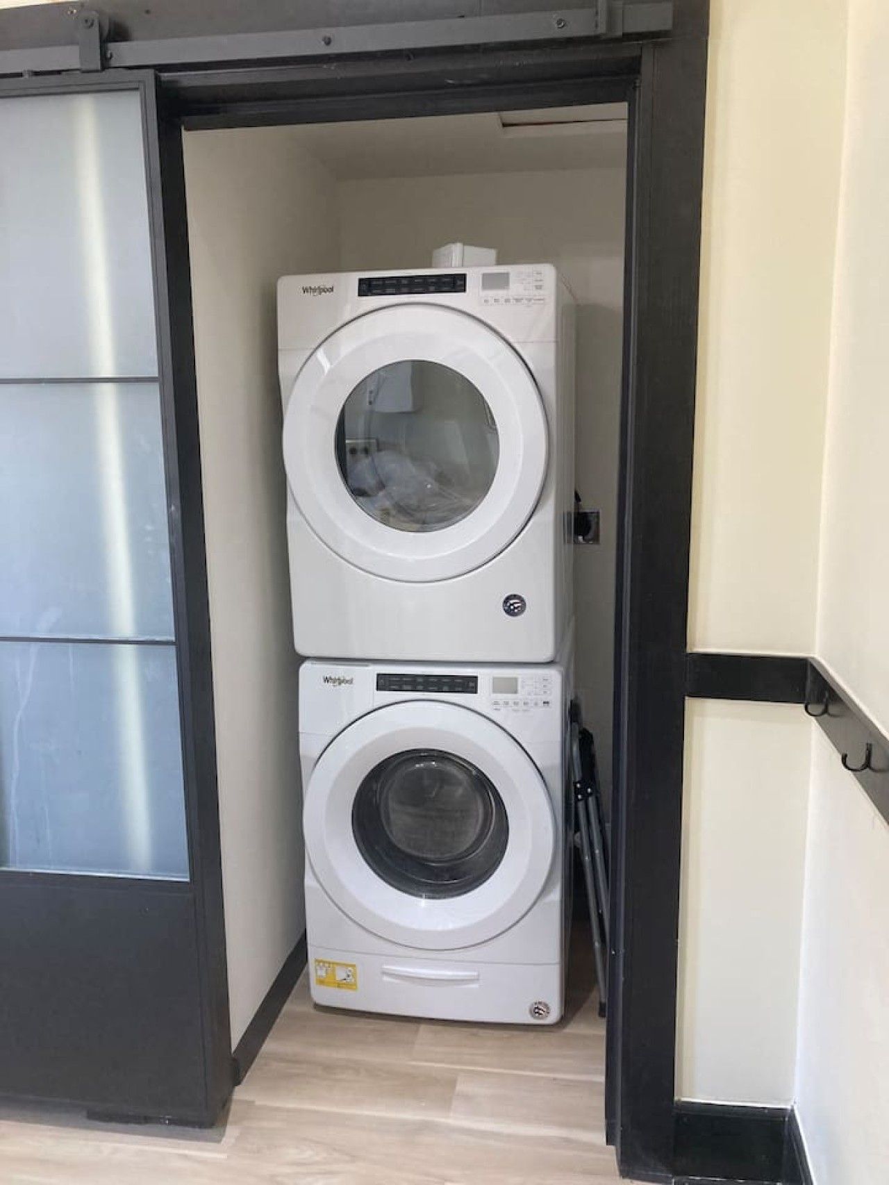 Una lavanderia compatta con due lavatrici Whirlpool affiancate.