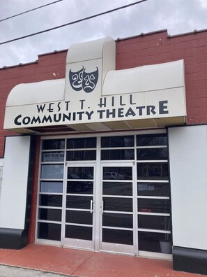 West T. Hill Community Theatre set fra ydersiden, med et skilt over indgangen.