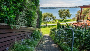 Una escalera conduce a una terraza con vistas a un lago y colinas al fondo.