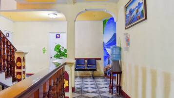 Un pasillo de hotel con una escalera, un dispensador de agua y una puerta marcada con el número 5.