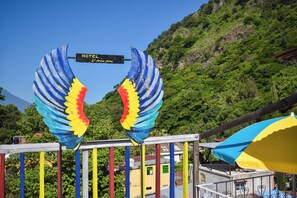 A hotel sign with a colorful wing design and a sign indicating the hotel name. - Hotel el Amigo (Panajachel)