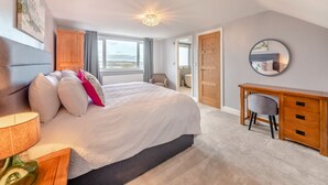 A bedroom with a bed, a desk, a chair, a mirror, and a view of the outdoors. - 2 bedroom accommodation in Quebec (Quebec)