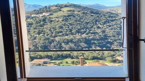 Une pièce avec une fenêtre donnant sur un paysage montagneux.