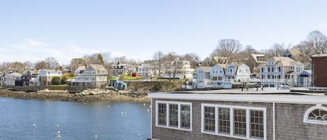 A waterfront property with a dock, houses in the background, and a clear sky.