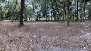 A campground with several RVs, picnic tables, and a small cabin. - RAINBOW RANCH CABINS (Dunnellon)