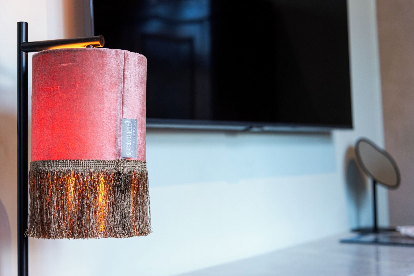 Una lámpara roja con textura y etiqueta en un interior moderno.