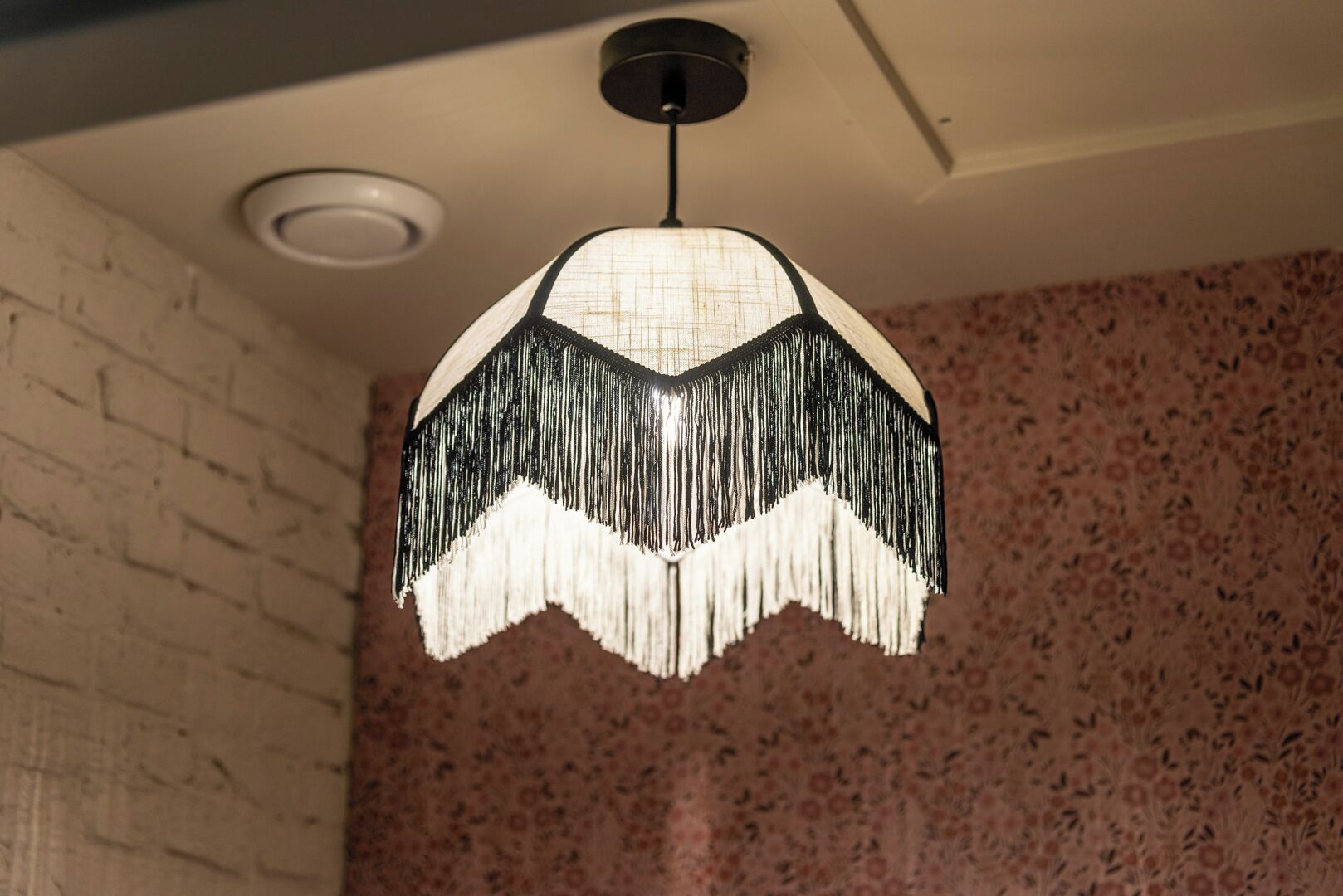 A pendant light with a fringed design hanging from the ceiling.