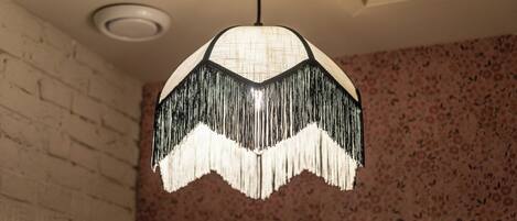 A pendant light with a fringed design hanging from the ceiling.